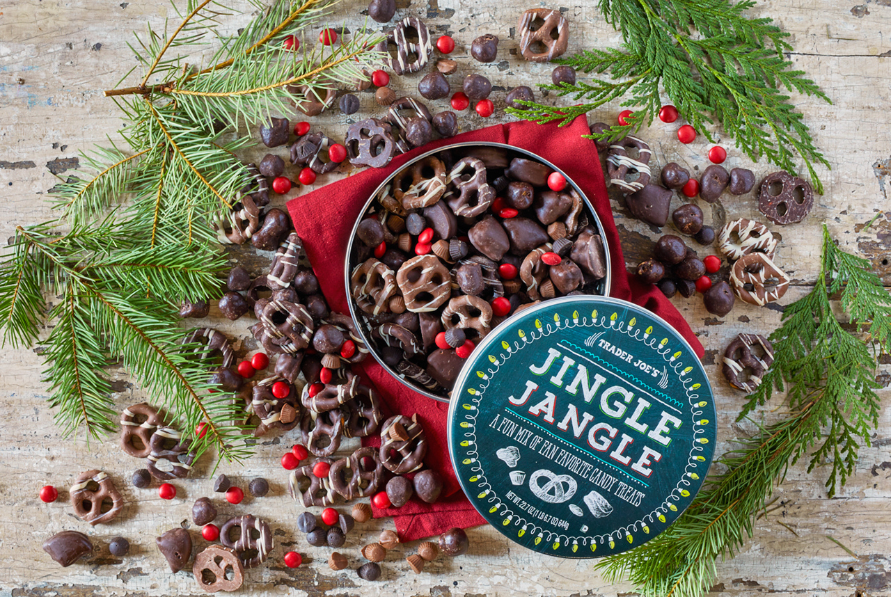 Trader Joe's Jingle Jangle spilling out of its tin onto a festive surface with red linen and pine branches