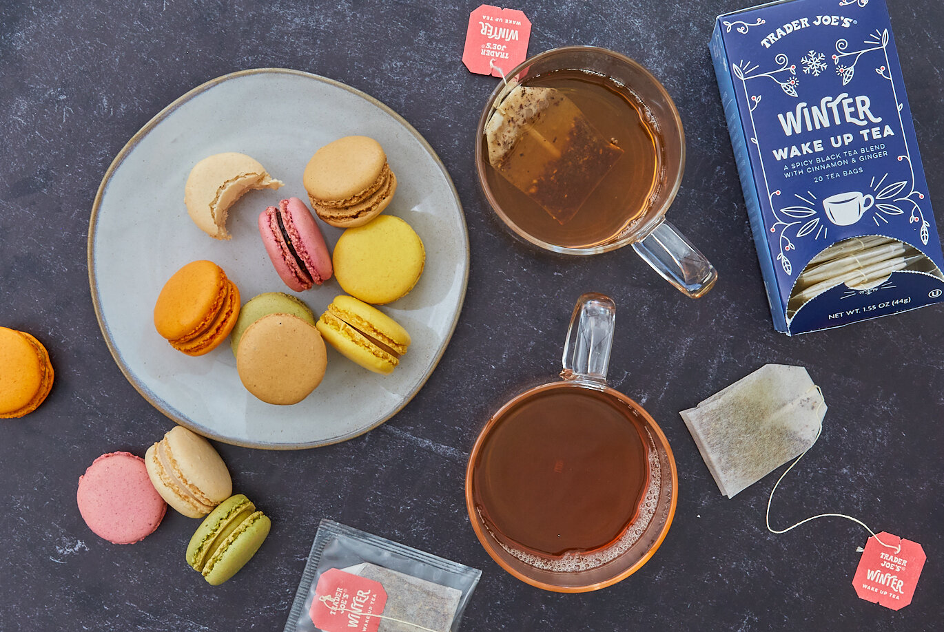 Trader Joe's Winter Wake Up Tea steeping in two mugs, a plate of Macaron cookies next to them