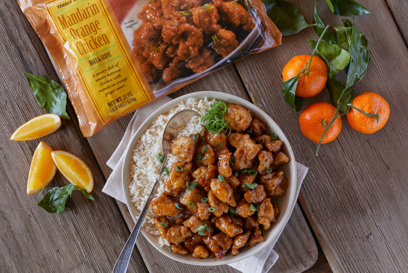 Trader Joe's Mandarin Orange Chicken served in a bowl with brown rice and sliced green onions