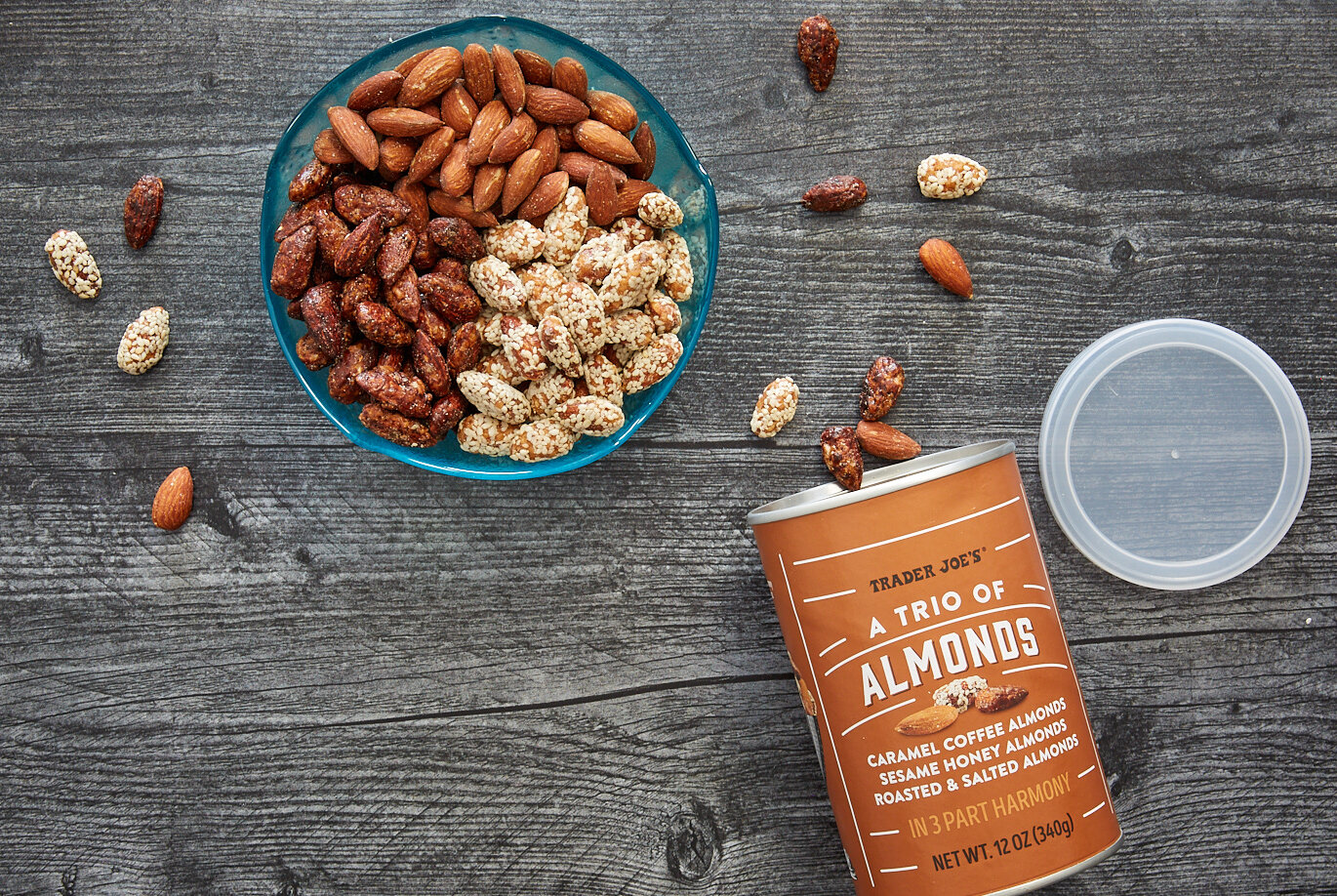 Trader Joe's Trio of Almonds in a blue bowl, separated out by variety, a few amonds scattered on surface