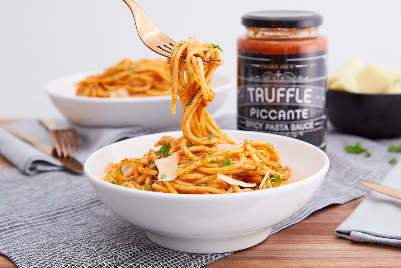 Trader Joe's Truffle Piccante Spicy Pasta Sauce prepared with spaghetti in a bowl; a fork is pulling strands up
