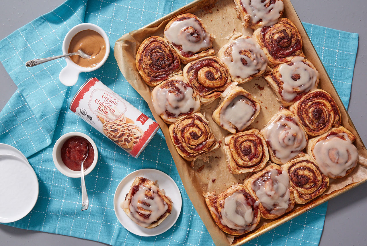 Trader Joe's Organic Jumbo Cinnamon Rolls used in recipe for Peanut Butter & Jelly Cinnamon Rolls; shown on baking tray with icing on some of them