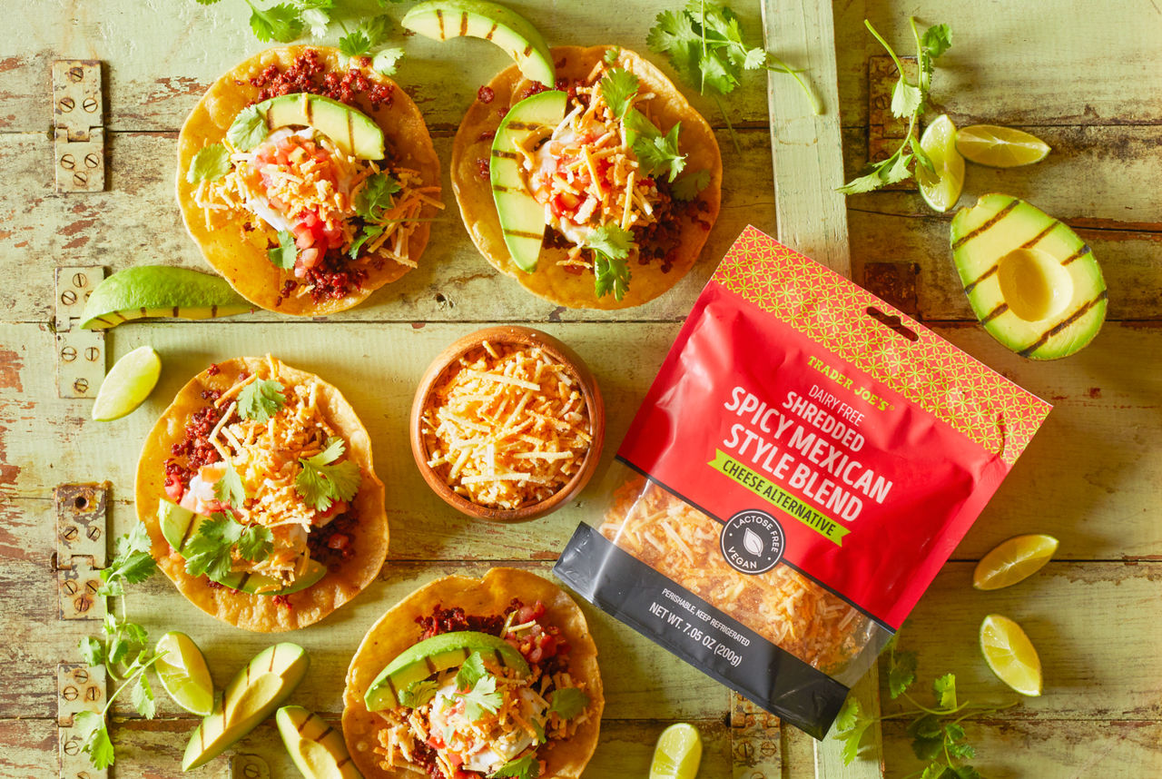 Trader Joe's Dairy Free Shredded Spicy Mexican Style Blend Cheese Alternative; shown on top of tostadas filled with soyrizo, pico de gallo and avocado slices