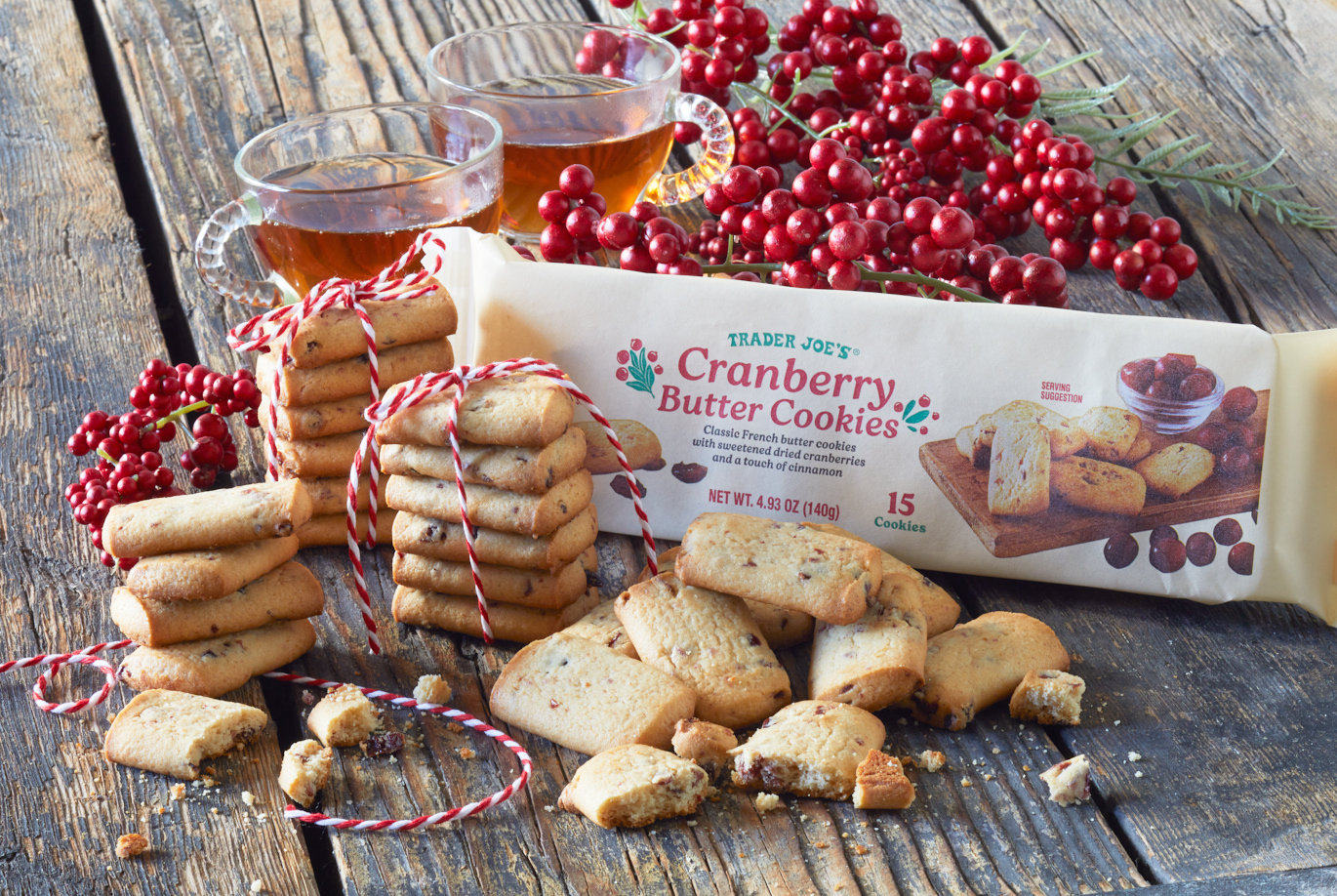 Trader Joe's Cranberry Butter Cookies; on rustic wood surface surrounded with red berries and two teacups