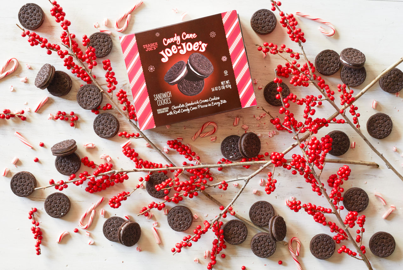 Trader Joe's Candy Cane Joe-Joe's, on white wood surface scattered with broken candy cane pieces and winter berry branches