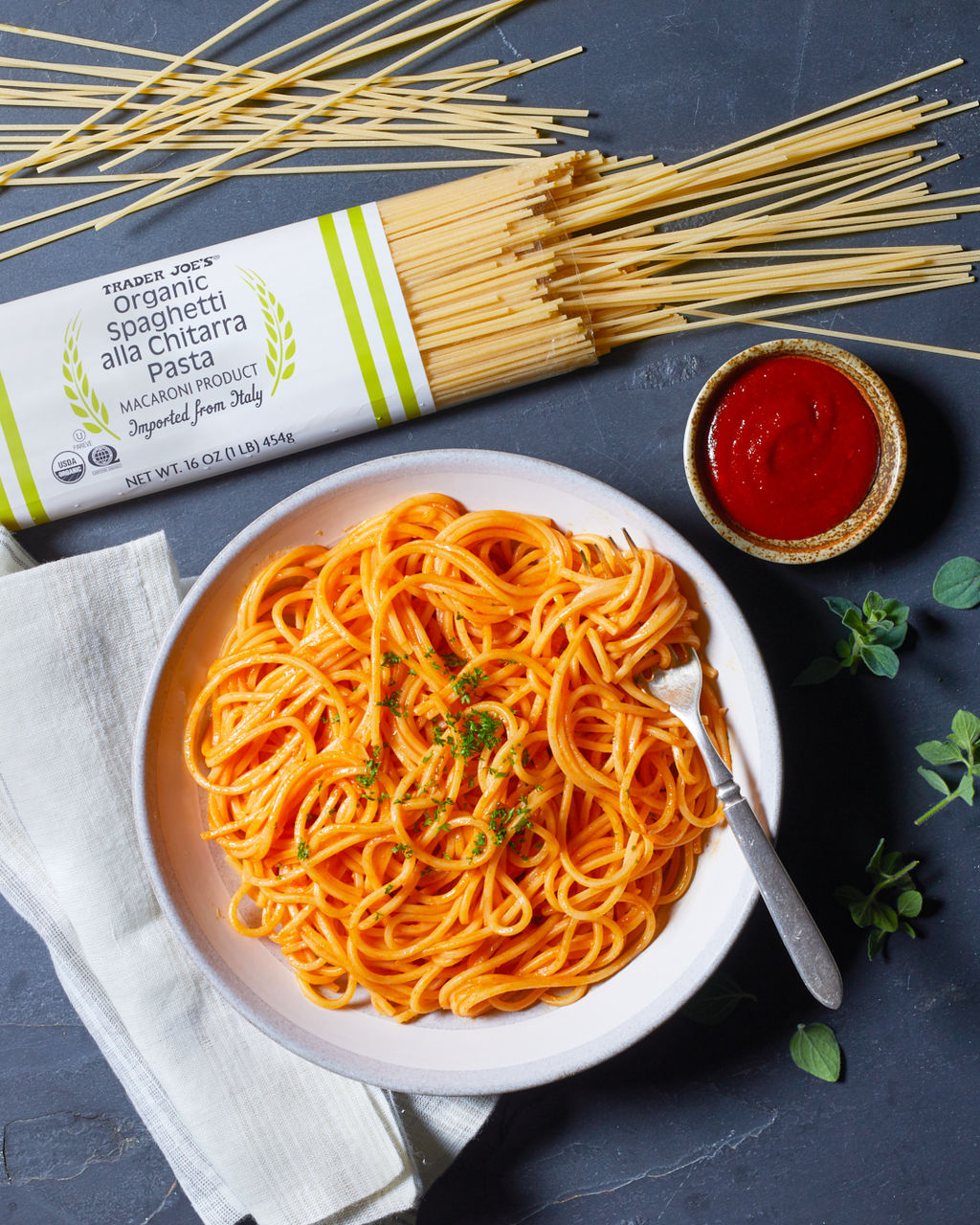 Fusilli, rigatoni and pens pasta in a green, blue and orange jar