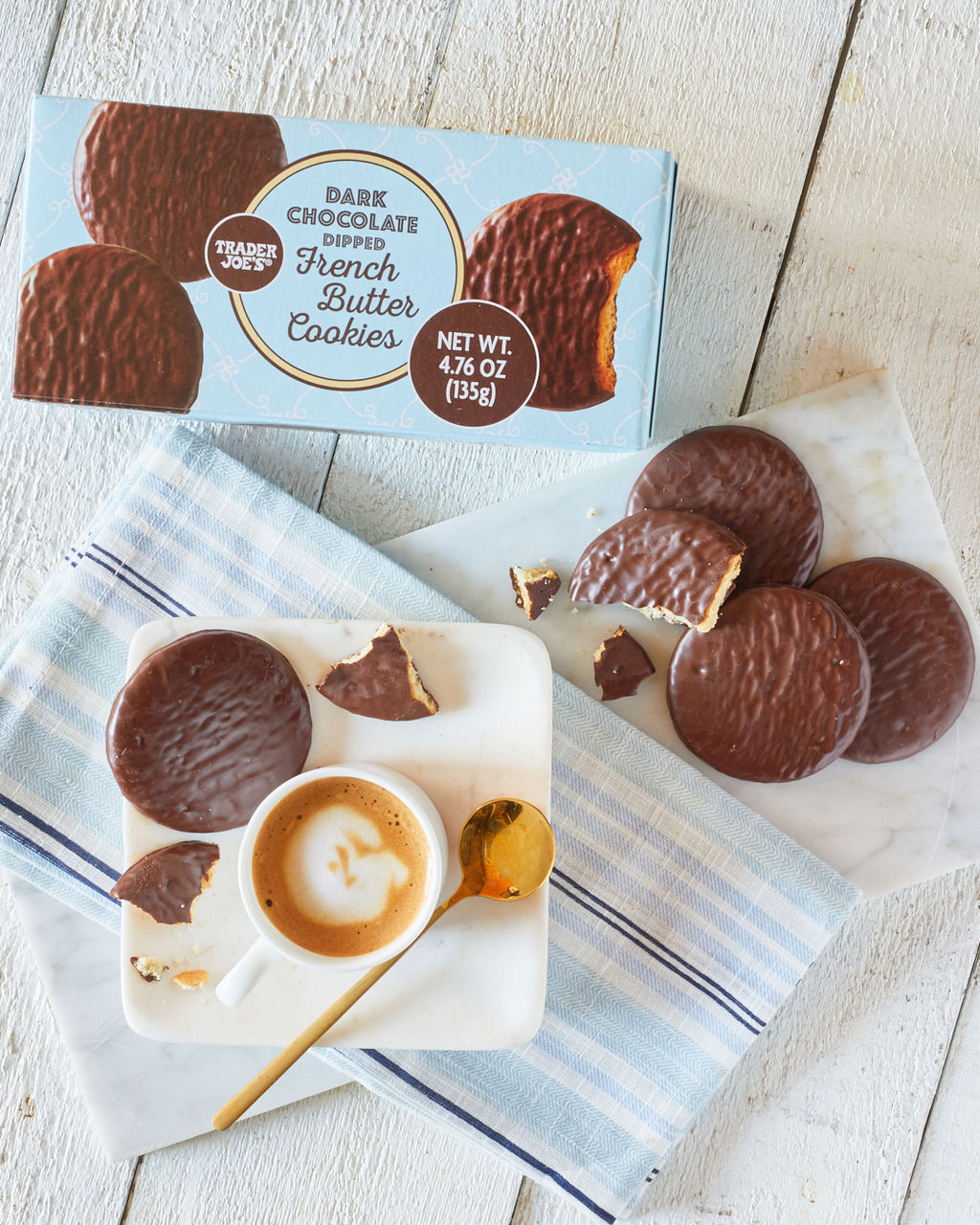 Trader Joe's Dark Chocolate Dipped French Butter Cookies; white wood surface with marble platter and white coffee cup, cookies surrounding